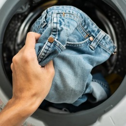 someone placing jeans in a machine