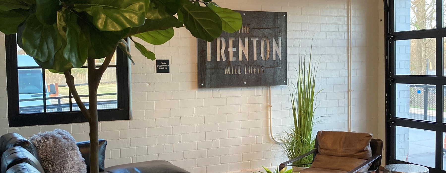 a room with a sign on a wall and a large window